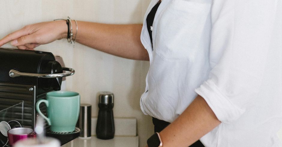 Žena pripravuje kávu na kávovare.