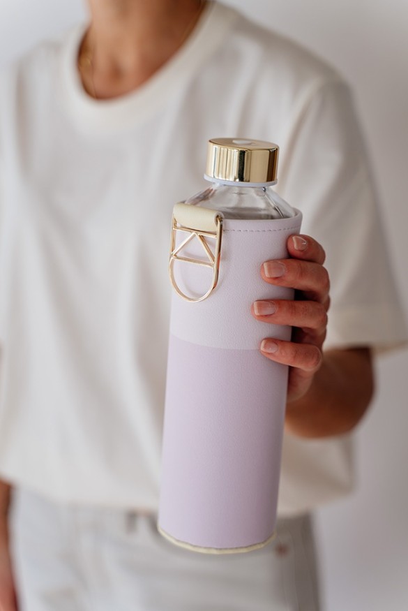 žena drží v ruke sklenenú fľašu