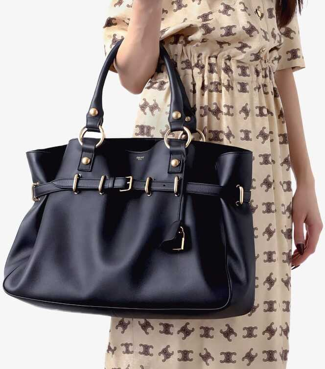 žena vo vzorovaných šatách s čiernou kabelkou