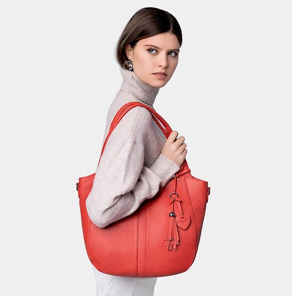 žena s červenou kabelkou na ruke