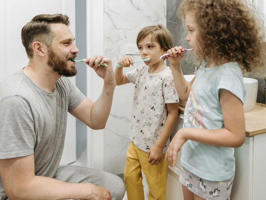 otec a deti si čistia zuby