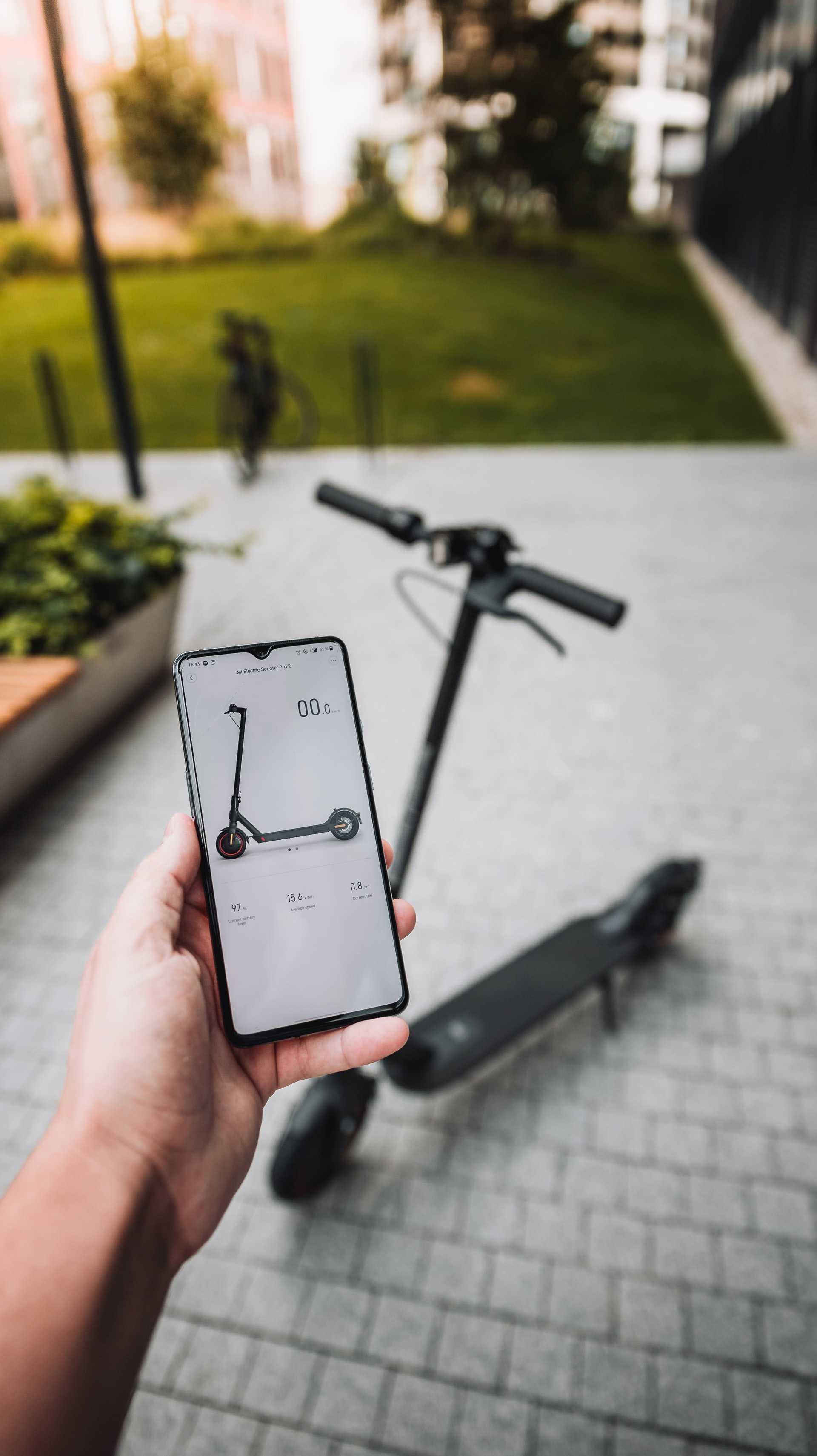 mi - otvorena aplikacia na kolobezku v mobile a za nim kolobezka
