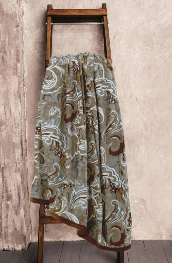 Mikroplyšová deka v hnedých farbách prevesená cez drevený sušič