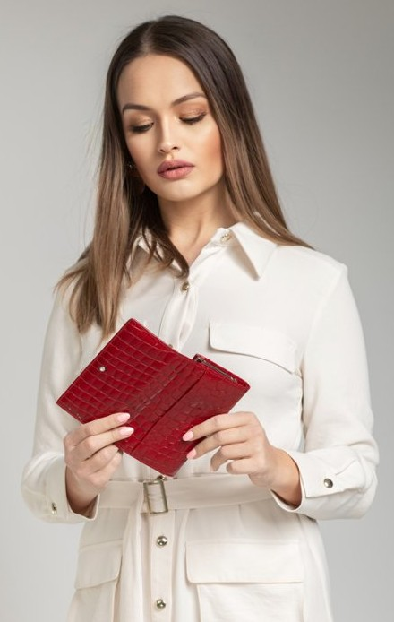 žena drží červenú peňaženku v rukách