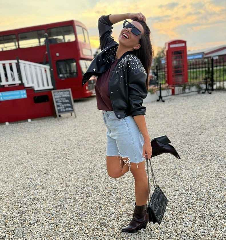 London club - žena pózuje pred červeným autobusom