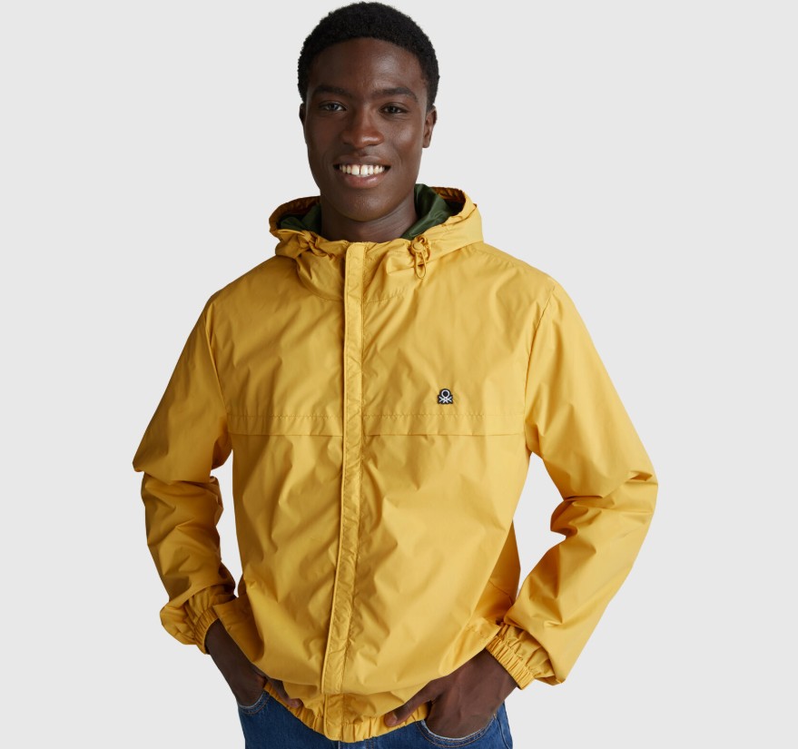 muž oblečený v žltej bunde do dažďa