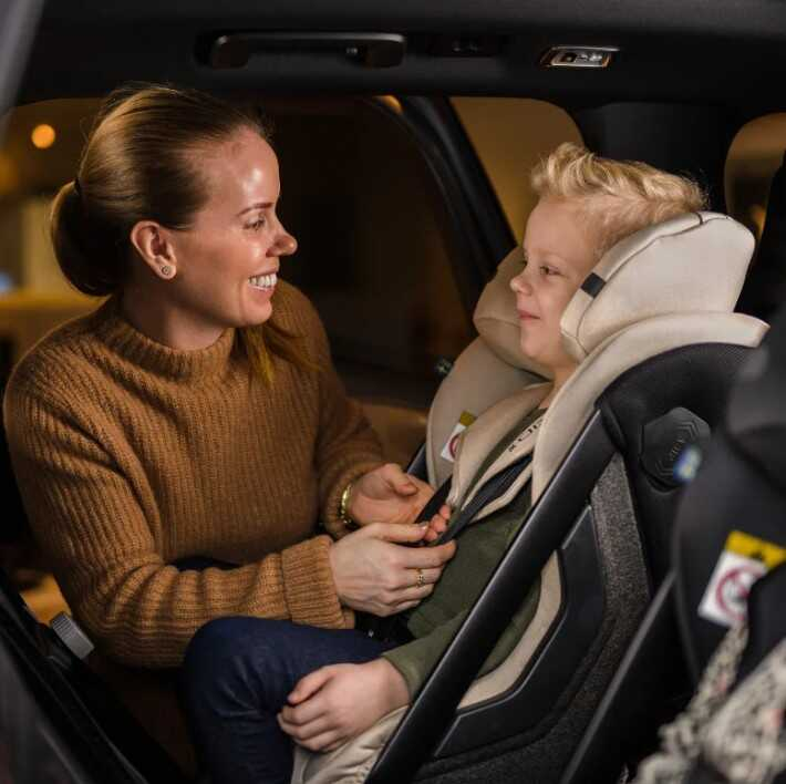 žena zapína dieťa do autosedačky