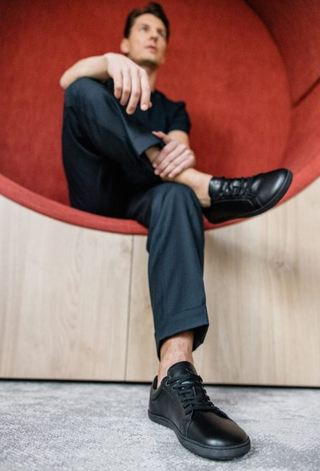 muž v elegantných čiernych barefoot teniskách