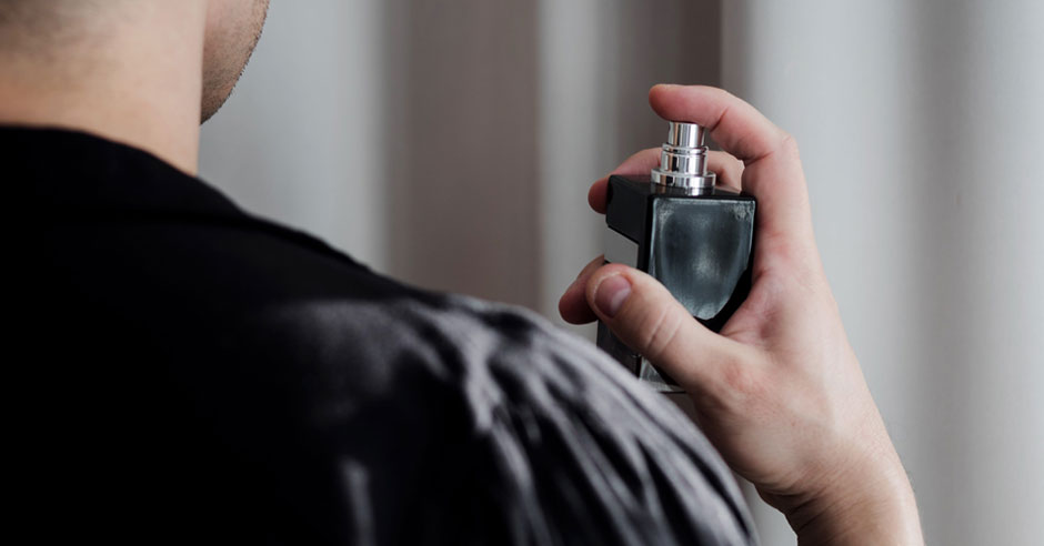 muž na seba aplikuje parfum