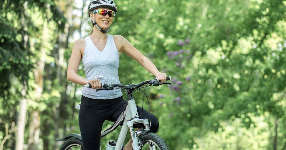 usmiata žena na bicykli v pr&iacute;rode